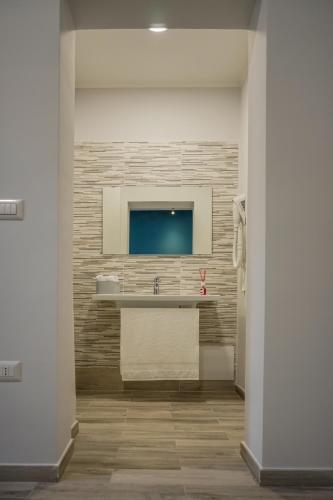 a bathroom with a sink and a tv on a wall at B&B Le Canapine in Frattamaggiore