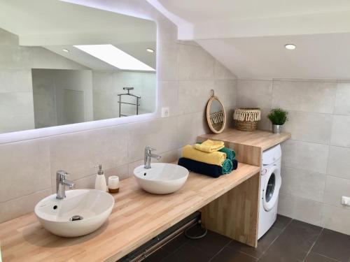 La salle de bains est pourvue de 2 lavabos et d'un lave-linge/sèche-linge. dans l'établissement Location Seignosse, à Seignosse