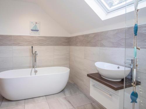 a bathroom with a white tub and a sink at Nyth y Fran in Menai Bridge