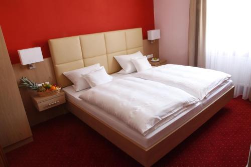 ein Schlafzimmer mit einem großen Bett mit weißer Bettwäsche und Kissen in der Unterkunft Hotel-Gasthof-Kohlmeier in Kranzberg