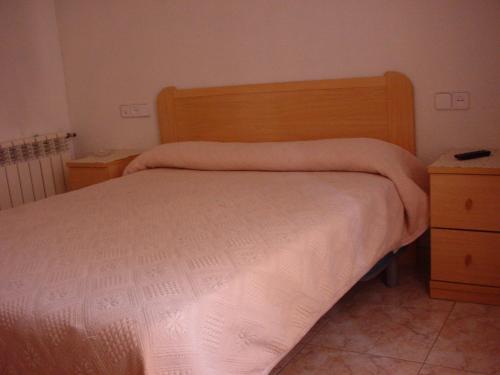 - une chambre avec un lit et une tête de lit en bois dans l'établissement Hostal Casanova, à Madrid