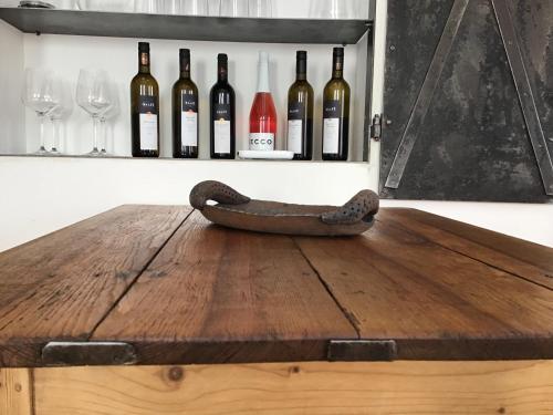a wooden table with a bunch of wine bottles on a wall at Apartmány Sebastian in Mikulov