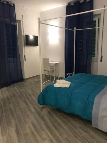 een slaapkamer met een bed met een blauwe deken en een tafel bij LunaBlù Cinecitta' in Rome