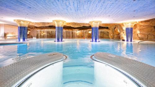 a swimming pool in a hotel with two chairs in it at Bull Eugenia Victoria & Spa in Playa del Ingles