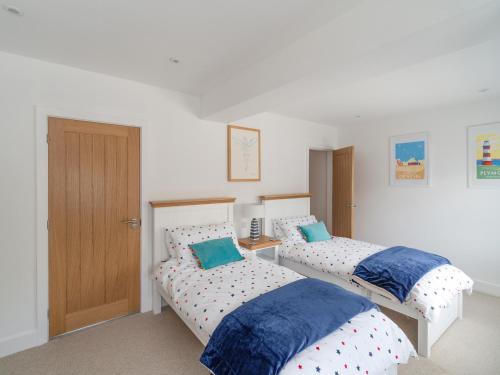 a bedroom with two beds and a door at Two Hoots in Kingsbridge