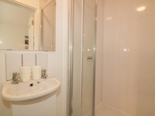 a bathroom with a sink and a shower at Summer Breezes in Newquay