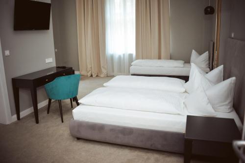 a hotel room with two beds and a desk and a computer at Villa Ljiljana in Vinkovci