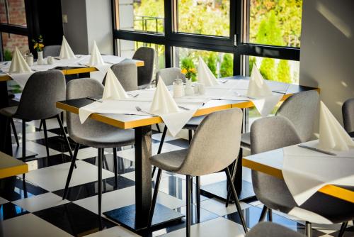 a row of tables and chairs with paper napkins on them at Villa Ljiljana in Vinkovci