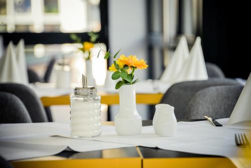 a table with two vases and a glass jar with flowers at Villa Ljiljana in Vinkovci