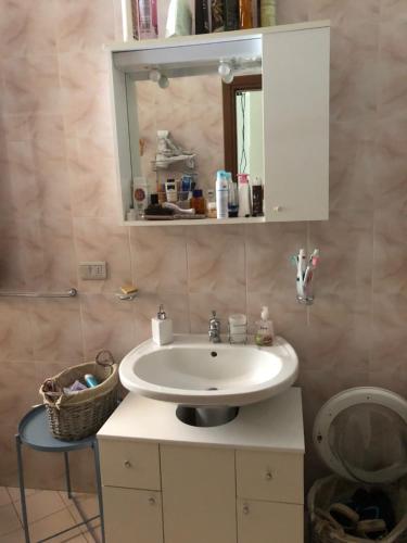 W łazience znajduje się umywalka i lustro. w obiekcie Appartamento curato con giardino w mieście Marina Romea