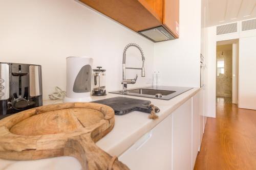 a kitchen with a wooden stool on a counter at Prime Lisbon - Sao Paulo 5 in Lisbon