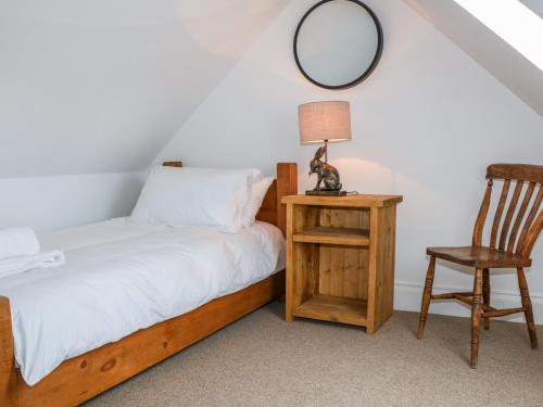 a bedroom with a bed and a chair and a mirror at Highcroft in Belper
