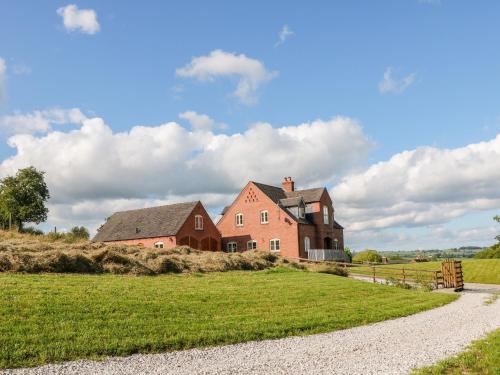 an old house on a hill with a grass field at Highcroft in Belper