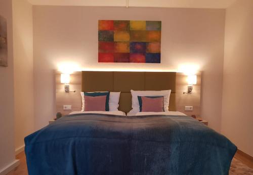 ein Schlafzimmer mit einem großen blauen Bett mit zwei Lichtern in der Unterkunft Hotel Am Kurpark in Brilon