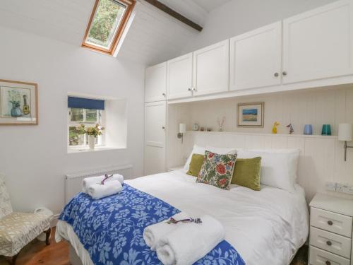 1 dormitorio con 1 cama con toallas en The Old White Cottage, en Shillelagh