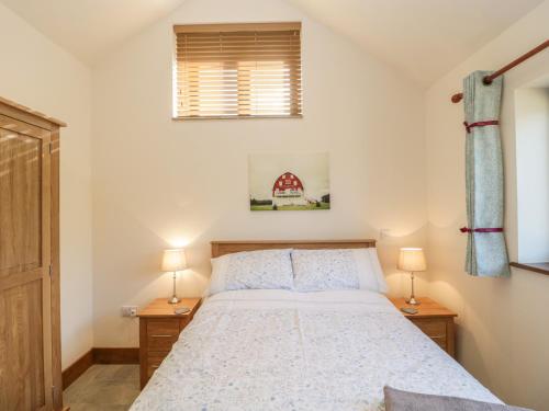 um quarto com uma cama grande e 2 candeeiros em The Milking Barn em Yeovil