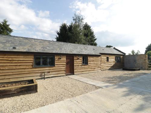 a wooden cabin with a driveway in front of it at The Milking Barn in Yeovil