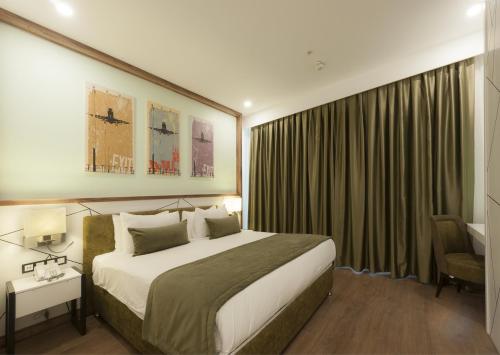 una habitación de hotel con una cama grande y una silla en ISG Sabiha Gökçen Airport Hotel en Estambul
