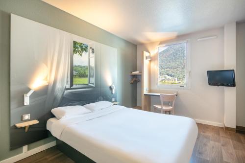 a hotel room with a large bed and a window at B&B HOTEL Saint Jean De Maurienne in Sainte-Marie-de-Cuines