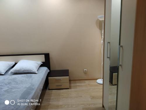 a small bedroom with a bed and a glass door at Цитадель к15 in Omsk