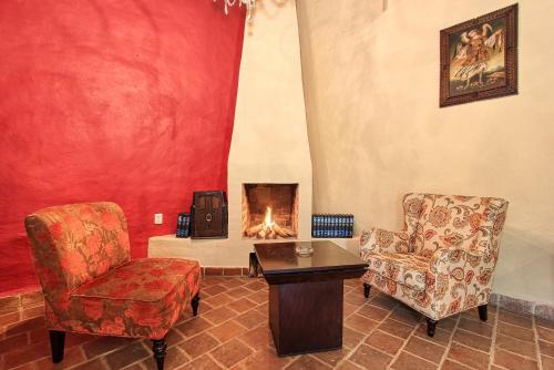 a living room with a chair and a fireplace at Hotel San Marcos in San Cristóbal de Las Casas