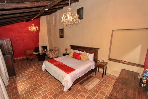 a bedroom with a bed and a chandelier at Hotel San Marcos in San Cristóbal de Las Casas
