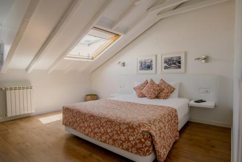 a bedroom with a bed and a skylight at Casa das Aguarelas in Ericeira
