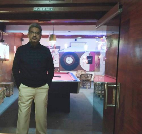 a man standing in front of a room with a car at Hotel The Galaxy in Mirzāpur