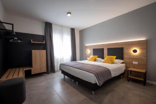 una camera da letto con un letto grande con cuscini gialli di Appartamenti Tre Colline a Bardolino