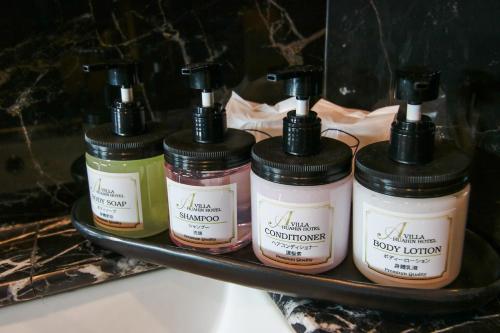 a group of four bottles of moisturizers on a shelf at A Villa Hua Hin Hotel in Hua Hin