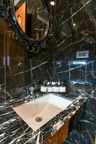 a bathroom with a sink and a mirror at A Villa Hua Hin Hotel in Hua Hin