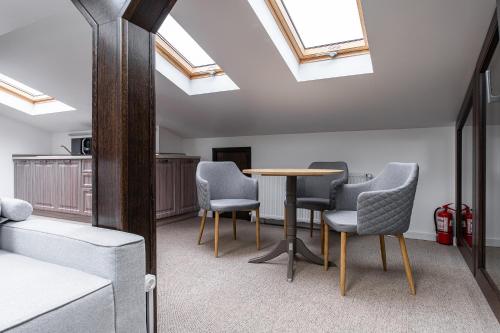 a room with a table and chairs and skylights at VILA NORBE in Buşteni