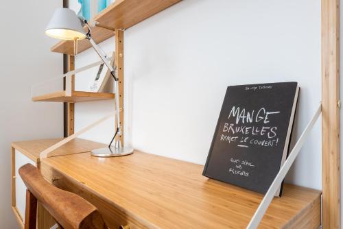 a desk with a lamp and a chalkboard on it at Newton Boutique Hotel Residences - Brussels EU Area in Brussels