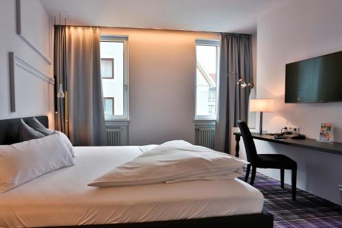 a hotel room with a bed and a desk at Hotel Schempp in Bobingen
