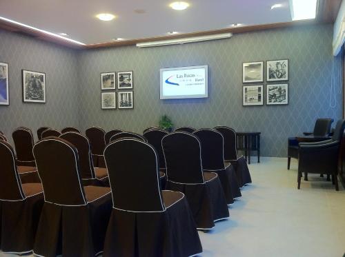 a conference room with chairs and a screen at Las Rocas Playa Hotel in Castro-Urdiales
