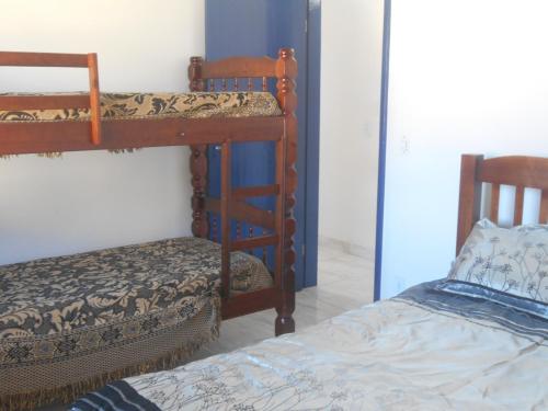 um quarto com dois beliches e uma cama em Apartamento perto de praia Dos Anjos em Arraial do Cabo