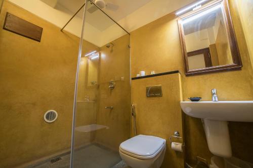 a bathroom with a shower and a toilet and a sink at Petit Palais in Puducherry
