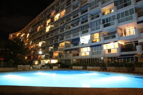 un gran edificio de apartamentos por la noche con piscina en Apartment with a great sea view in the best location of Santa Ponsa, en Santa Ponsa