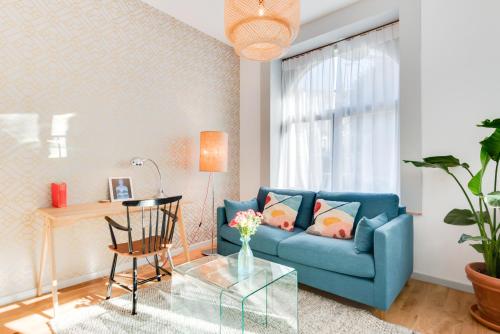 a living room with a blue couch and a table at Newton Boutique Hotel Residences - Brussels EU Area in Brussels