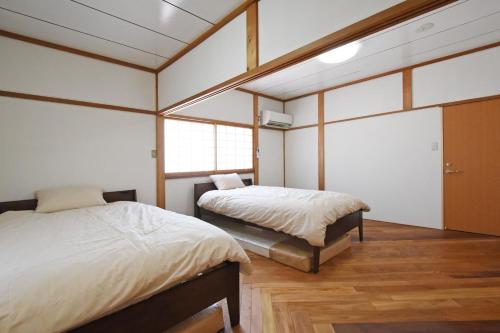 מיטה או מיטות בחדר ב-一棟貸し切り ゲストハウス Sai