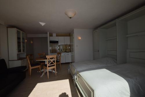 1 dormitorio con cama, mesa y cocina en Zeedijk 336, en Middelkerke