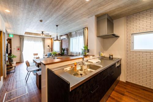 宜野灣的住宿－ペンション マカナレアビーチ沖縄，一个带大水槽和台面的厨房