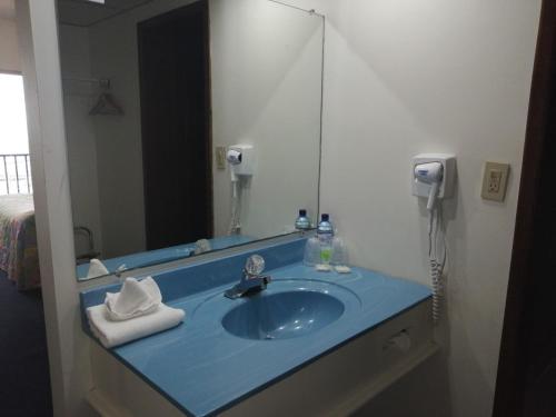 y baño con lavabo azul y espejo. en Hotel Villa Marina, en Ensenada