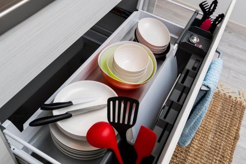 a drawer in a kitchen with plates and utensils at ペンション マカナレアリゾート沖縄 in Ginowan
