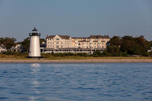 a lighthouse in front of a large building and the water at Harbor View Hotel in Edgartown