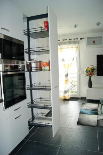 une cuisine avec une étagère, des casseroles et des poêles dans l'établissement Victoria-T2-41m2-Balcon, wifi, linge, produits, ménage inclus, à Reims