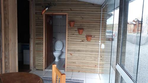 a bathroom with a toilet with plants on the wall at Pousada e Restaurante Redivo in Louro Müller