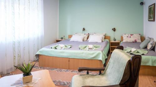 1 Schlafzimmer mit 2 Betten, einem Tisch und Stühlen in der Unterkunft Apartman Sara - Delnice in Delnice