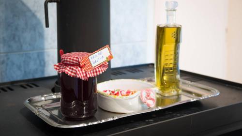 a tray with a bottle of oil and a bowl of food at Apartman Sara - Delnice in Delnice