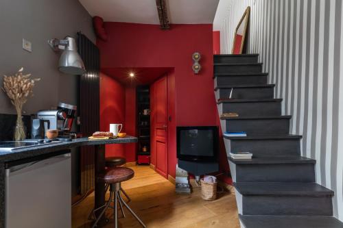 パリにあるAppartement Luxe Montorgueil bail mobilité Opera Louvreの赤壁の台所の階段